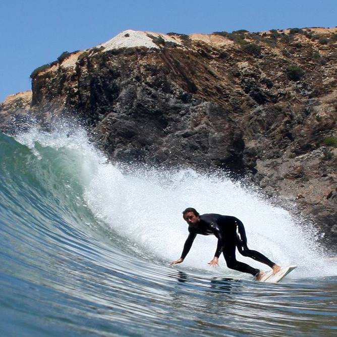 Odeceixe Surfer catching wave in Algarve